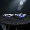 Flat lay photography of the vintage pear cut blue sapphire twig engagement ring and matching vine band arranged on a soft neutral background to showcase the full design.