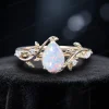 Front view of the 1.25ct pear cut white opal ring set crafted in 14k yellow gold, featuring the same nature inspired leaf vine bypass design as an alternative metal option.