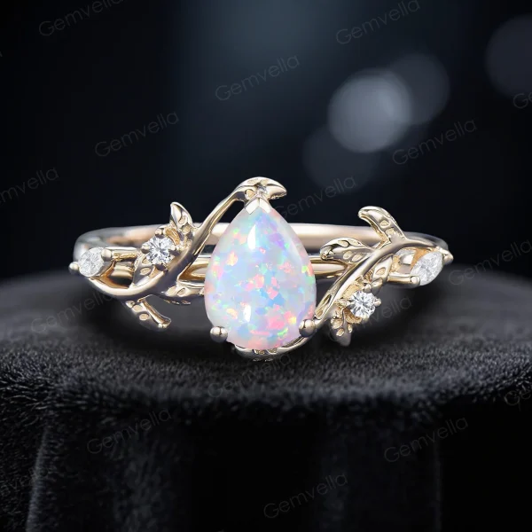 Front view of the 1.25ct pear cut white opal ring set crafted in 14k yellow gold, featuring the same nature inspired leaf vine bypass design as an alternative metal option.