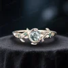 Close-up of a vintage style moss agate ring crafted in solid yellow gold. The round cut green agate is accented by genuine emeralds in a celestial moon and star setting, perfect for nature inspired brides.