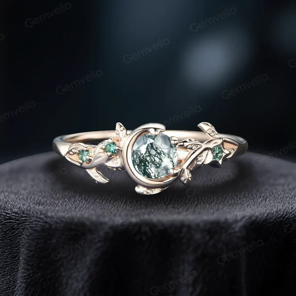 Close-up of a vintage style moss agate ring crafted in solid yellow gold. The round cut green agate is accented by genuine emeralds in a celestial moon and star setting, perfect for nature inspired brides.