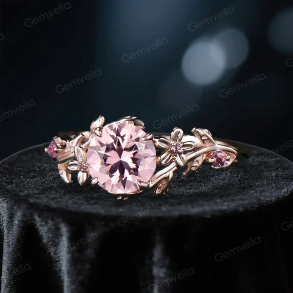 Angled three quarter view of a vintage round cut pink sapphire engagement ring with pink tourmaline accents showcasing the floral design depth and craftsmanship