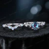Flat lay photography of the two-piece ring set separated to show the detailed craftsmanship of the matching bands, highlighting the organic leaf patterns on both the engagement ring and the accompanying wedding band.