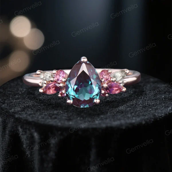Close - up front view of the 1.25ct pear - shaped alexandrite main engagement ring. The cluster setting features pink tourmaline and moissanite stones, with visible rose gold prongs securing the pear - cut alexandrite at the center.