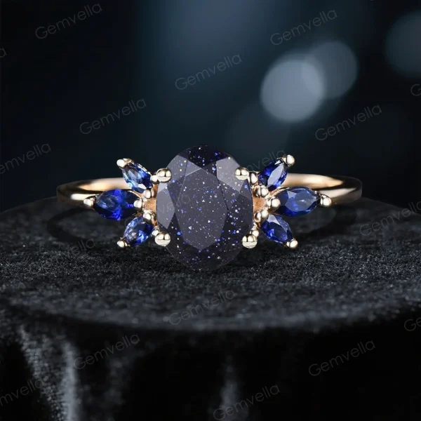 variation of galaxy starry sky ring showcasing 1.5ct oval blue sandstone main stone paired with deep blue sapphire side stones.