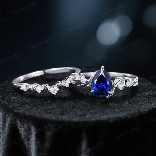 Flat lay photography of the 1.25ct blue sapphire and sterling silver nature-inspired ring set, showcasing the pear cut stone and intricate vine details.