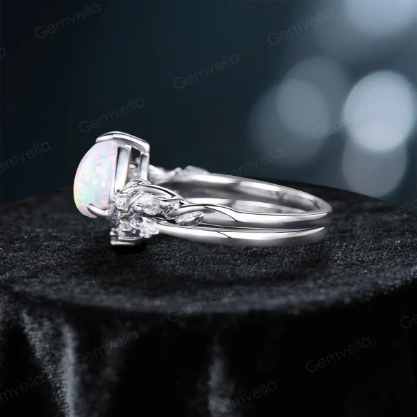 Side profile of 1.25ct pear cut opal engagement ring set showing the sterling silver twig vine band thickness, opal stone setting height, and nature inspired leaf accents on the side of the ring