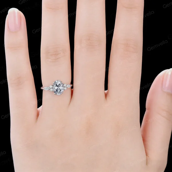 Close-up shot of a woman's hand wearing the 1.5ct oval moissanite ring with marquise accents, displaying the ring's elegant look on the finger as a perfect engagement gift.