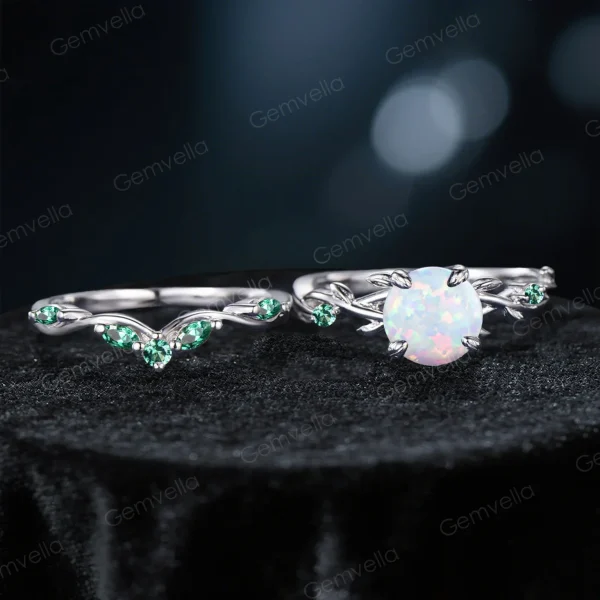 Flat lay of the vintage 1.2ct round cut opal engagement ring set with green emerald accents and twisting vine leaf band.