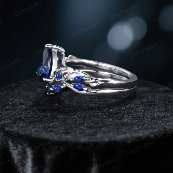 Side profile of the nature-inspired engagement ring highlighting the intricate twig vine detailing along the band and the elegant setting of the pear cut blue sapphire.