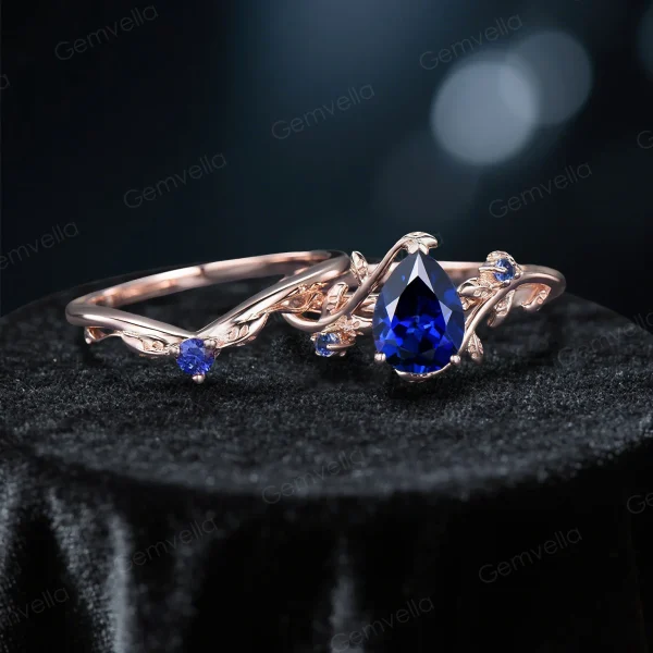 Flat lay photography of the complete nature inspired blue sapphire bridal set showing the engagement ring paired with the matching leaf motif wedding band