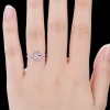 Woman wearing 1.5ct oval pink sapphire and marquise moissanite promise ring on finger for size reference