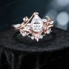 Angled view of 14K rose gold pear cut moissanite ring displaying stars moon and twisted vine design, handcrafted nature inspired bridal engagement ring set with three-dimensional details