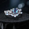 45-degree angle shot revealing the three-dimensional depth of the leaf and vine motif, the sparkle of the central Alexandrite, and the ethereal blue sheen of the surrounding Moonstones.