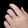 Lifestyle shot of a woman's hand wearing the 1.25ct pear shaped aquamarine wedding set, showcasing how the nature inspired yellow gold twig ring with sparkling moissanite leaves looks when worn and stacked on the finger.