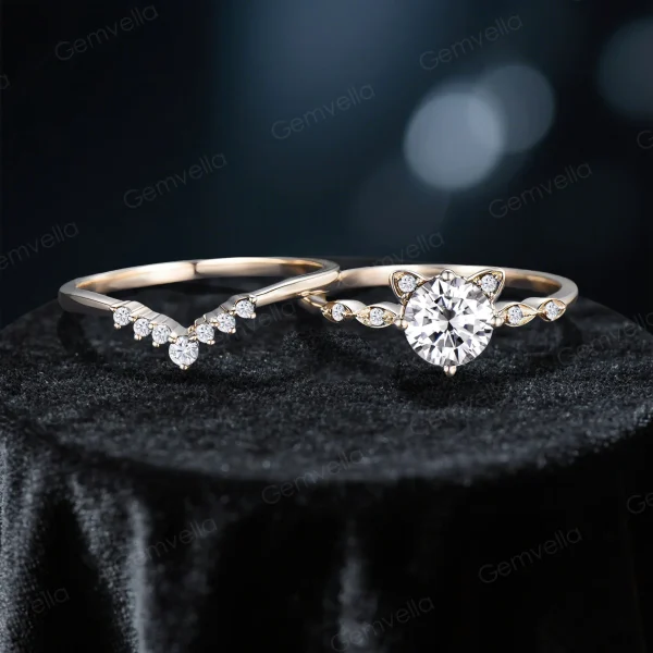 Flat lay image of the cat-themed bridal set, displaying the engagement ring with its round moissanite stone and cat ear accents alongside the matching yellow gold wedding band.