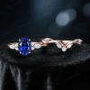 Flat lay of the 2-piece bridal set featuring the matching Blue Sapphire engagement ring and wedding band in 10k rose gold.