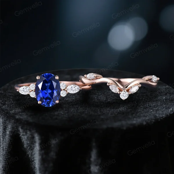 Flat lay of the 2-piece bridal set featuring the matching Blue Sapphire engagement ring and wedding band in 10k rose gold.