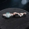 Flat lay of the 2-piece bridal set featuring the matching moss agate engagement ring and wedding band in 10k rose gold.