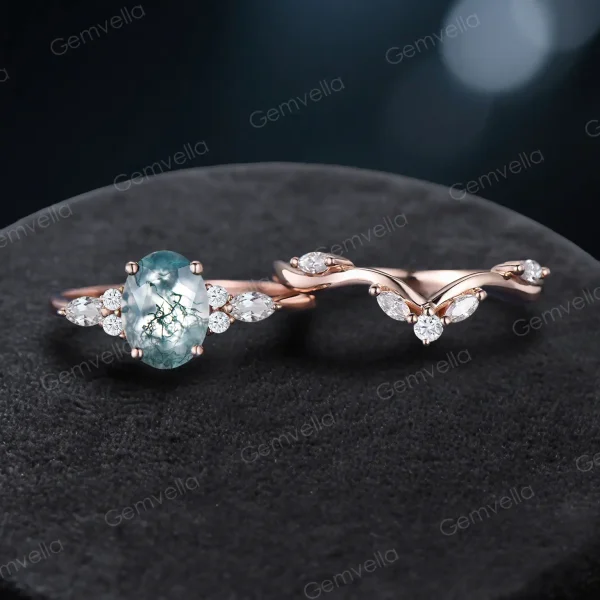 Flat lay of the 2-piece bridal set featuring the matching moss agate engagement ring and wedding band in 10k rose gold.