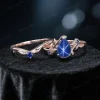Flat lay photography of the nature-inspired sapphire wedding set displaying the full silhouette of the pear-shaped stone and leaf accents.