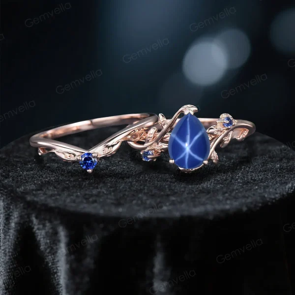Flat lay photography of the nature-inspired sapphire wedding set displaying the full silhouette of the pear-shaped stone and leaf accents.
