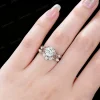 Lifestyle close-up of a woman's hand wearing the vintage 1.2ct round cut moissanite ring set, demonstrating the dainty stackable vine leaf design on the finger.