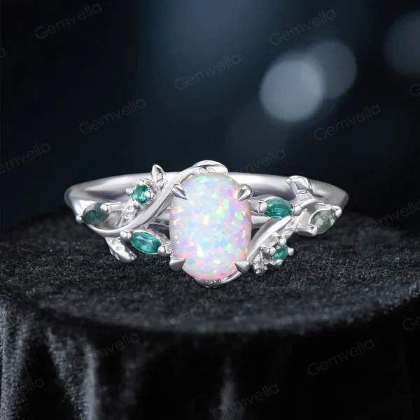 Sterling silver version of a nature-inspired bridal ring set, featuring a 1.5ct oval white opal center stone, leaf vine branch engagement ring with emerald and moss agate accents, and a matching emerald wedding band