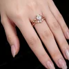 Lifestyle shot of a woman's hand wearing the 1.25ct pear shaped moissanite wedding set, showcasing how the nature inspired rose gold twig ring looks when worn and stacked on the finger.