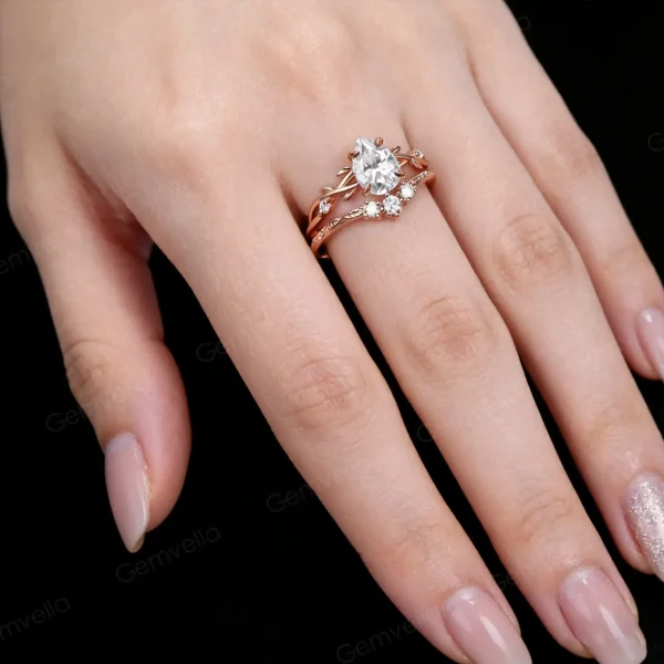Lifestyle shot of a woman's hand wearing the 1.25ct pear shaped moissanite wedding set, showcasing how the nature inspired rose gold twig ring looks when worn and stacked on the finger.