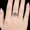 Woman hand wearing 1ct kite cut alexandrite celtic knot bridal set on finger showing color change effect and fit.