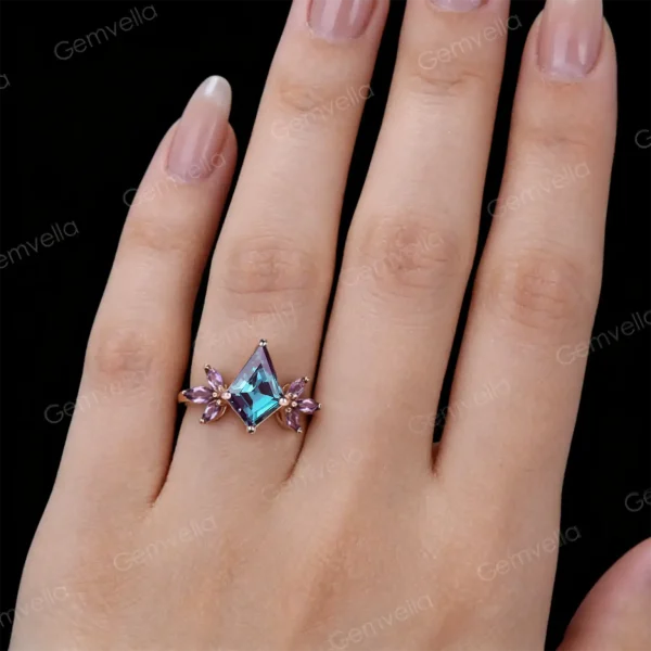 Woman's hand wearing vintage art deco kite alexandrite and amethyst wedding ring, close up lifestyle image.