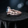 Side profile showing the intricate branch and leaf twist band design of the silver London Blue Topaz wedding ring set.