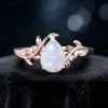 Detailed close-up front view of the main 1.25ct pear cut white opal engagement ring, showcasing the 14k rose gold setting and the delicate leaf vine design on the ring shank.
