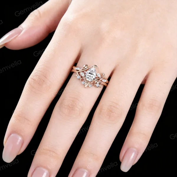 Close-up of 14K rose gold pear moissanite ring worn on hand, real life wear of stars moon and twisted vine engagement ring, nature inspired bridal jewelry showing fit and sparkle
