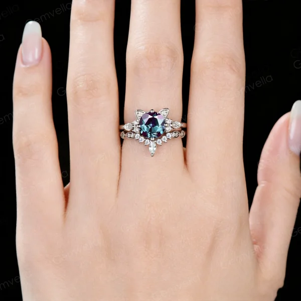 Lifestyle shot of a woman's hand wearing the unique cat themed engagement ring and wedding band set, demonstrating the fit and scale of the round alexandrite and moissanite jewelry on the finger.
