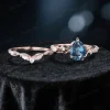 Flat lay photography of the two piece wedding set displaying the pear cut blue topaz engagement ring and matching nature inspired vine band.