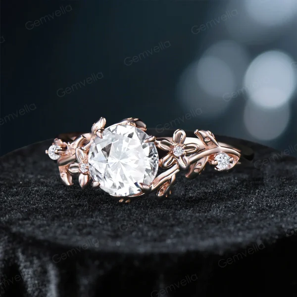 Angled view of a vintage round cut moissanite engagement ring, showing the relationship between the center stone and the 14k gold setting with its nature-inspired leaf vine branch details from a diagonal perspective.