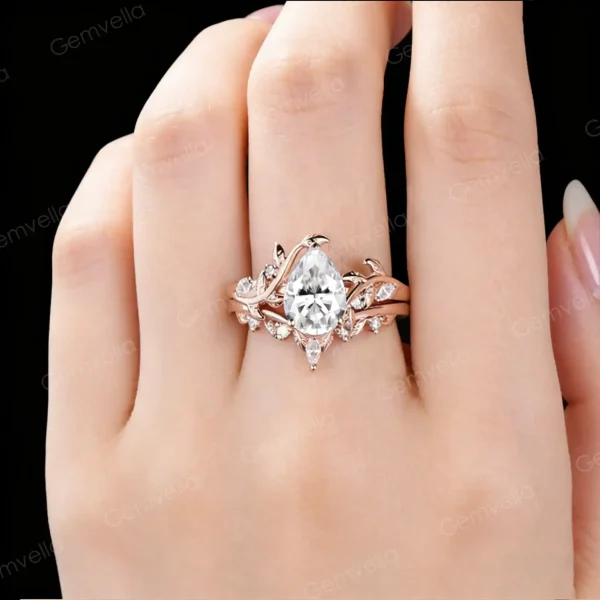 Lifestyle photo of a woman's hand wearing a 1.25ct pear moissanite bypass engagement ring in 14K rose gold, showing how the leaf vine branch design looks when worn, with natural lighting highlighting the moissanite sparkle and nature-inspired bridal jewelry aesthetic.