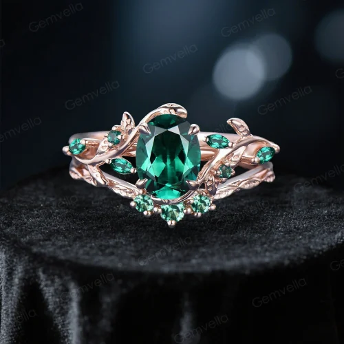 Front view of 1.5ct oval emerald bridal ring set in 10K rose gold, featuring nature inspired leaf vine branch design and vintage detailing