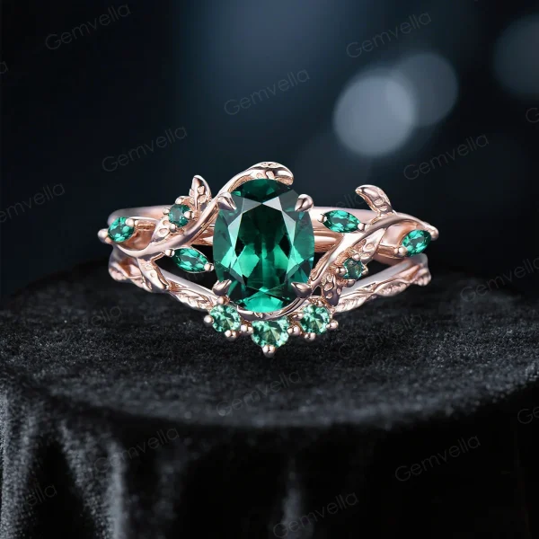 Front view of 1.5ct oval emerald bridal ring set in 10K rose gold, featuring nature inspired leaf vine branch design and vintage detailing