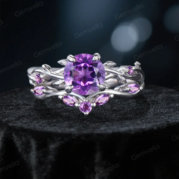Frontal view of a nature-inspired bridal ring set featuring a deep purple round cut Amethyst center stone, surrounded by an intricate sterling silver twisting vine and leaf setting paved with smaller sparkling Amethyst gems.