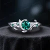 A bright and shiny 925 sterling silver emerald ring, highlighting the contrast between the silver metal and the deep green round cut stone with nature-inspired leaf and celestial details.