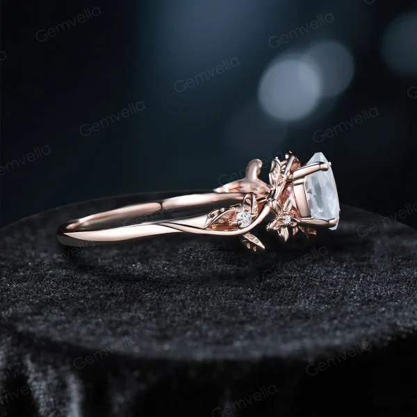 Side profile of a vintage 14k gold moissanite engagement ring, highlighting the thickness of the band and the detailed craftsmanship of the floral leaf and vine branch design wrapping around the shank.