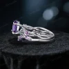 Side profile showcasing the substantial width of the sterling silver band, the raised cathedral setting of the central Amethyst, and the detailed leaf texture wrapping around the side of the ring shank with embedded purple stones.