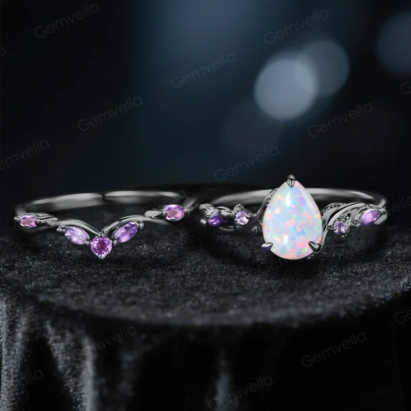 Flat lay of nature-inspired engagement ring set with 1.25ct pear-cut opal in black gold, elegant twig vine detail